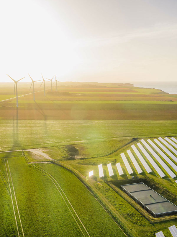 Freiflächen-Photovoltaikanlage und Windräder arbeiten zusammen für nachhaltige Energieerzeugung – SEICON Energy integriert Speicherlösungen für maximale Effizienz.