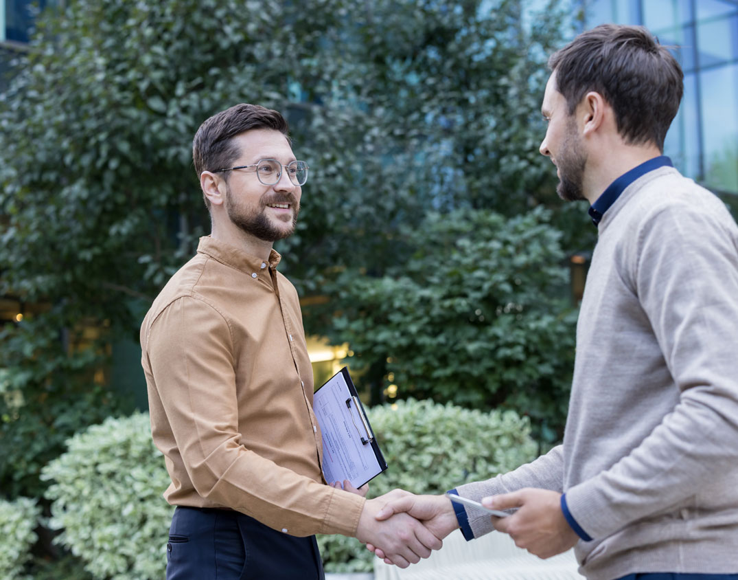 Zwei Geschäftspersonen besiegeln eine Vereinbarung per Handschlag – SEICON Energy unterstützt Unternehmen beim Erwerb hochwertiger Carbon Credits für nachhaltigen Klimaschutz.