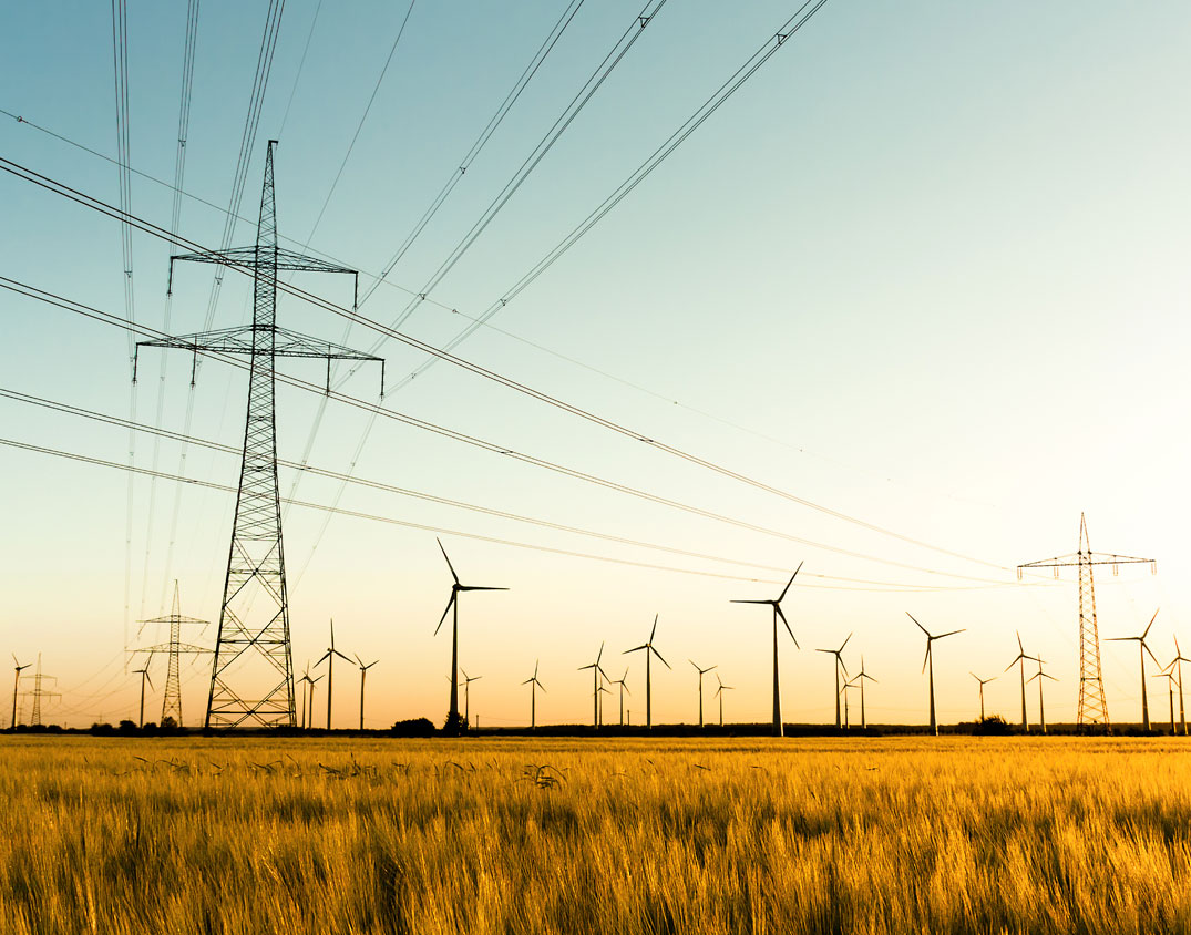 Electricity pylons and wind turbines in a rural field landscape – SEICON Energy analyses contracts and develops individual solutions for price stability, planning reliability, and economic efficiency in energy management.